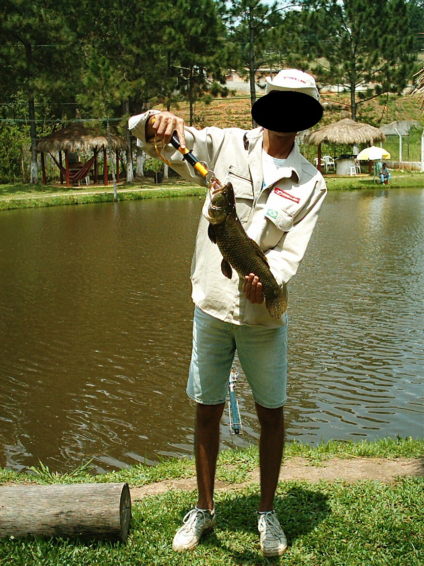 Pescador mostrando traira que acaba de pescar
